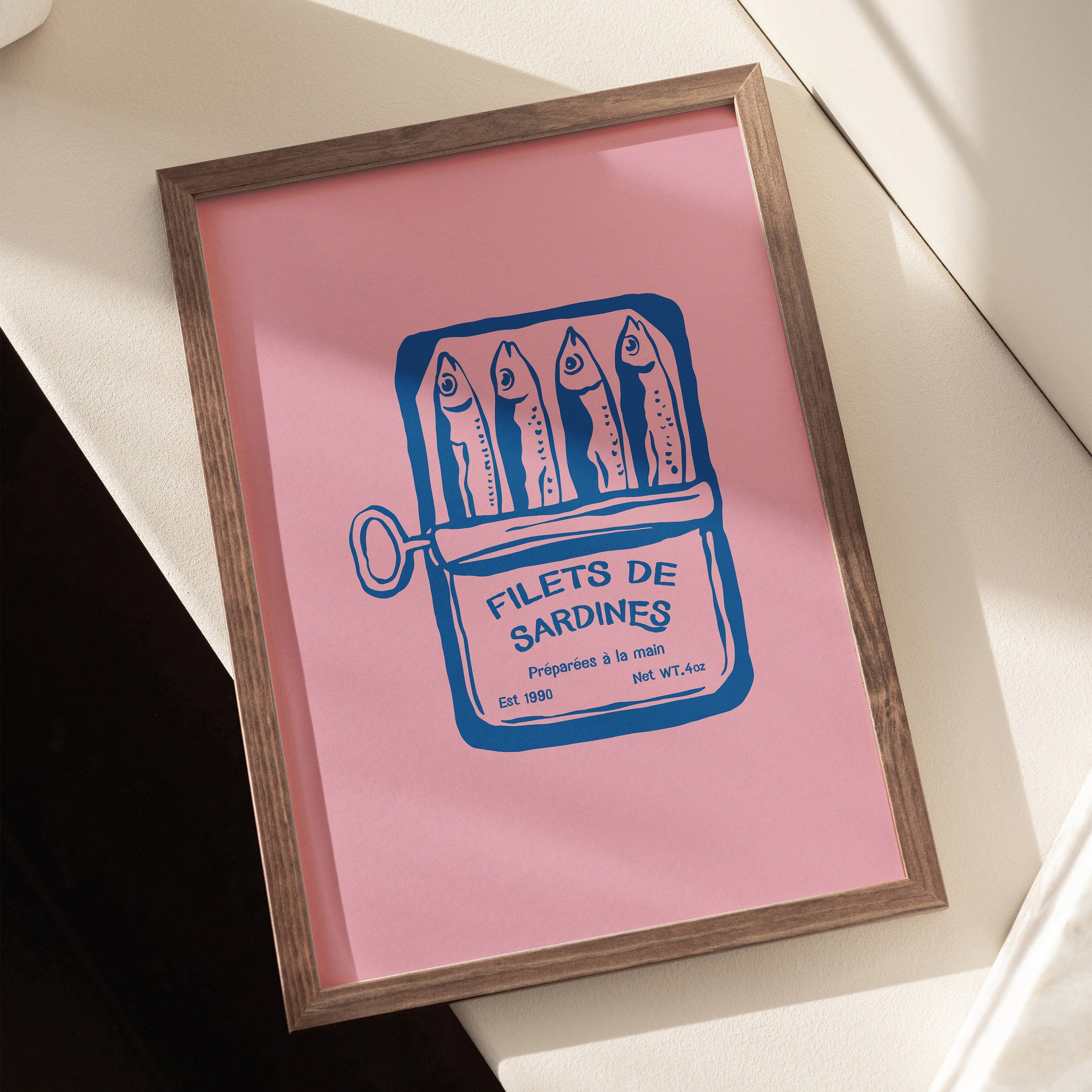Vintage art print of a sardine can labeled "Filets de Sardines" on pink background